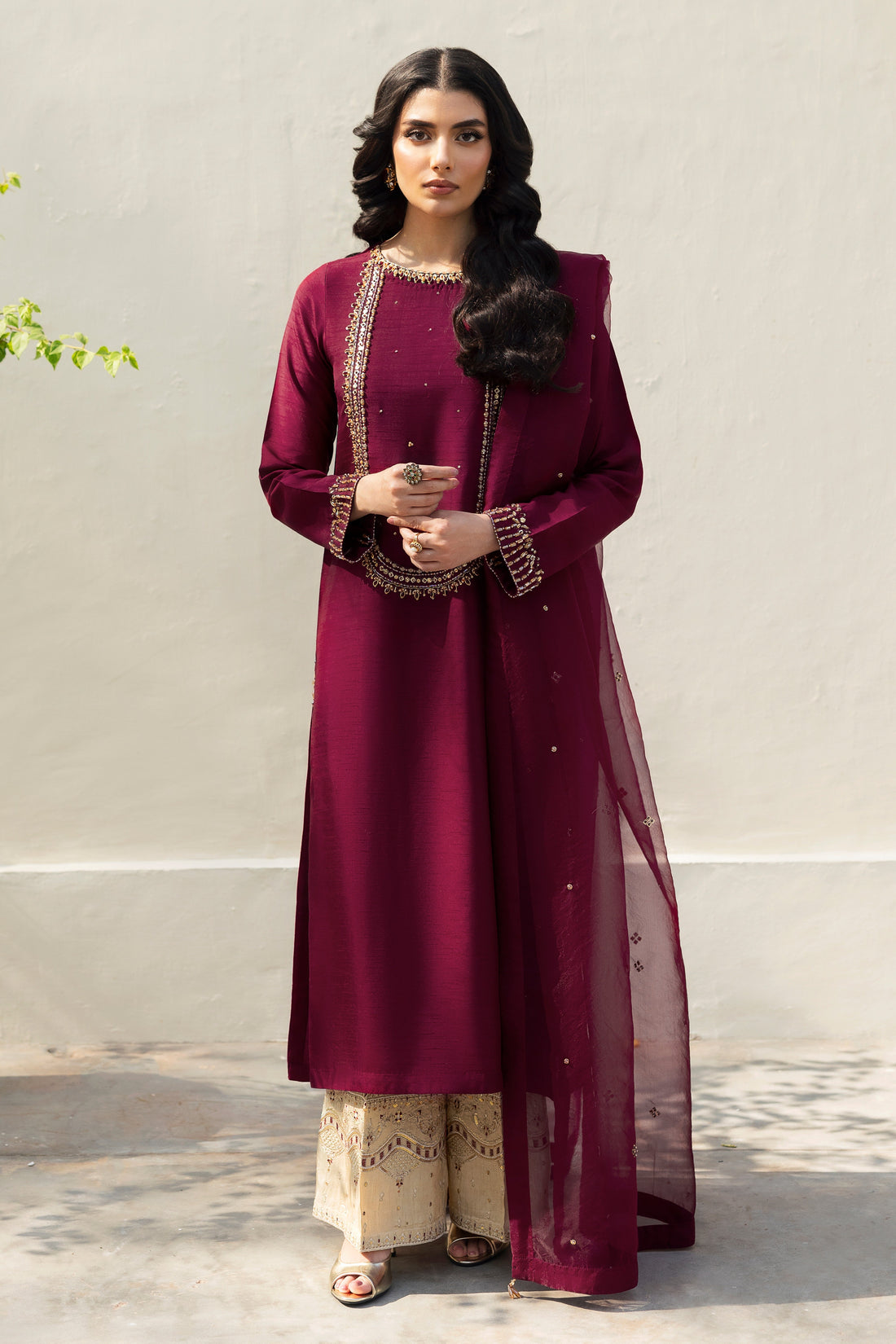 NAQSHI Parize burgundy raw‑silk straight shirt with boat neckline richly adorned in hand‑adda embellishments—kora, dabka, naqshi, sitara, cut dana, crystals & stonework; paired with skin‑tone sequin embroidery culottes.