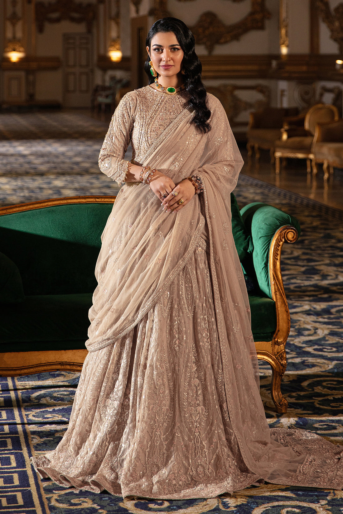 Naqshi Areeza skin‑gold net choli richly embroidered with hand‑adda motifs, sequin detailing, scalloped sleeves with dangling tassels, paired with voluminous lehanga.