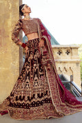 Side pose of Parivarsh maroon bridal dress showing wide lehenga flare and long dupatta trail, traditional ready made wedding attire.