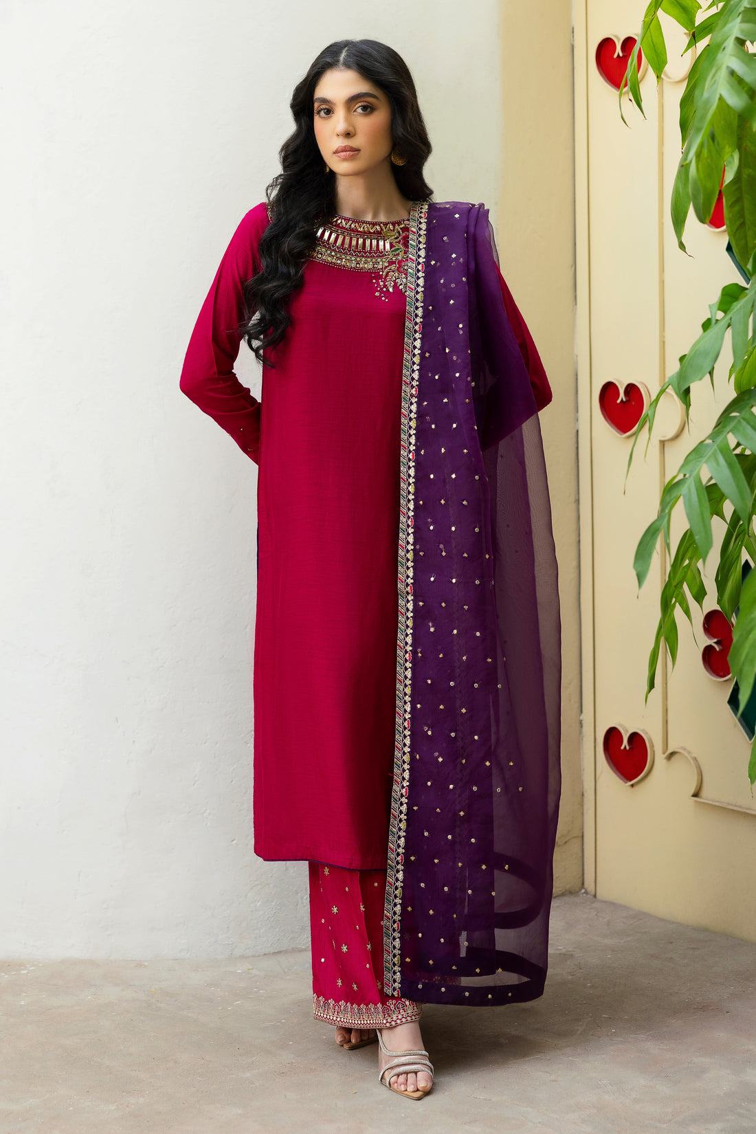NAQSHI Raima hot-pink Indian raw silk straight shirt with heavily hand-adda embellished near-to-neck neckline—kora, dabka, sitara, crystals, threadwork—paired with purple organza dupatta.
