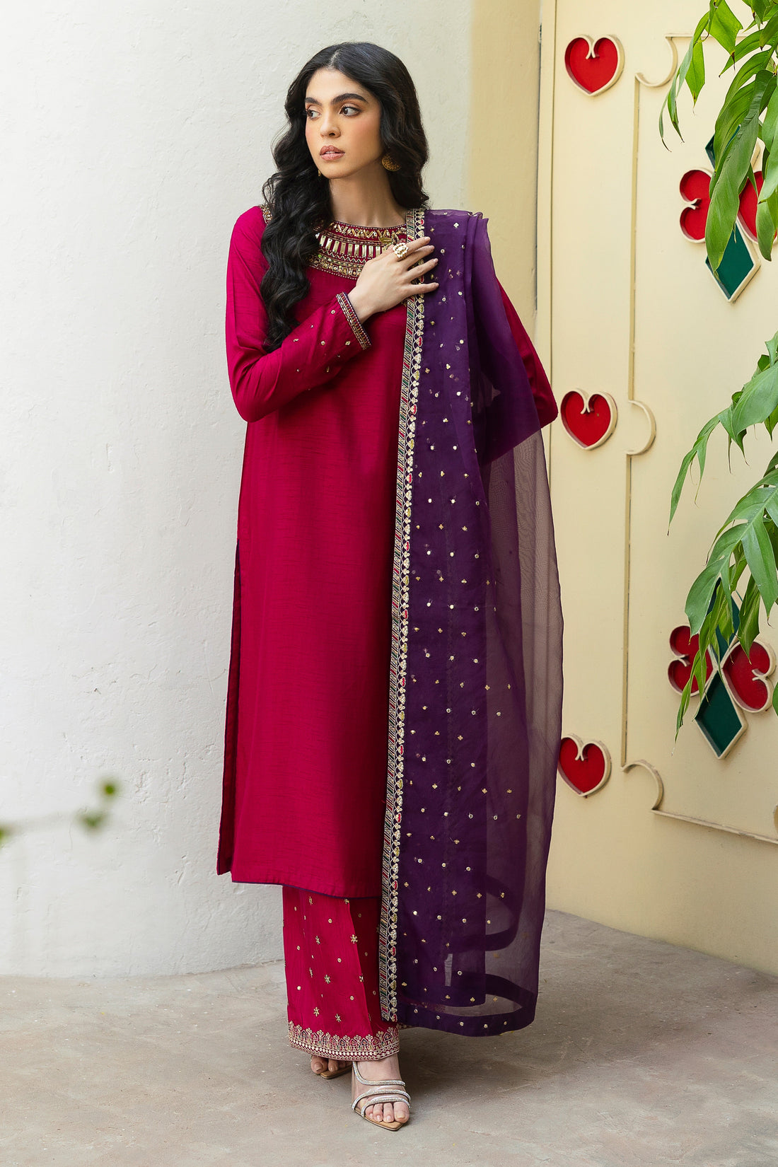 NAQSHI Raima hot-pink Indian raw silk straight shirt with heavily hand-adda embellished near-to-neck neckline—kora, dabka, sitara, crystals, threadwork—paired with purple organza dupatta.