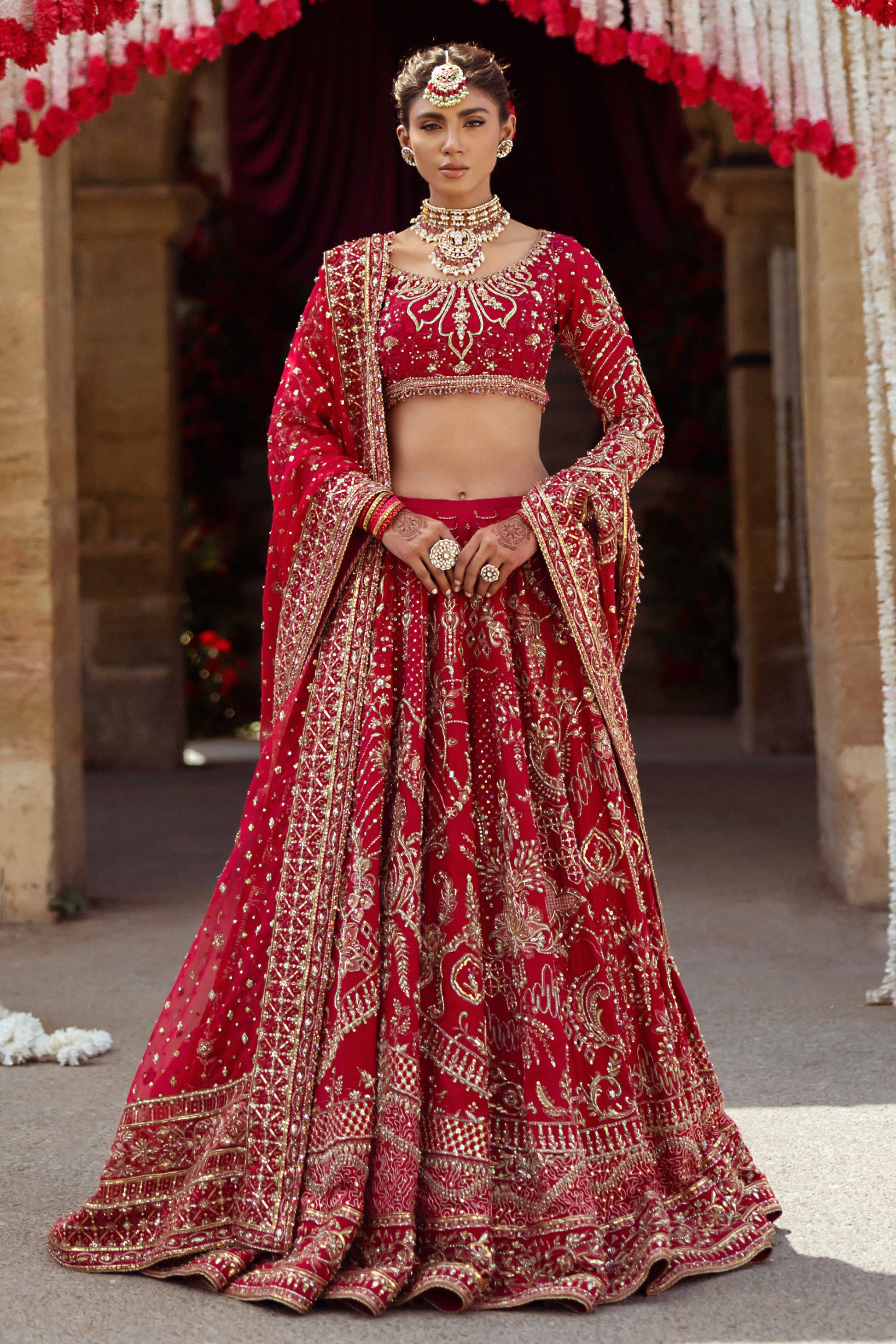 NAQSHI Qurbat fuchsia red bridal raw-silk lehenga front view with round embroidered neckline, scalloped three-quarter sleeves, richly hand-adda embellished choli, and layered lehenga.