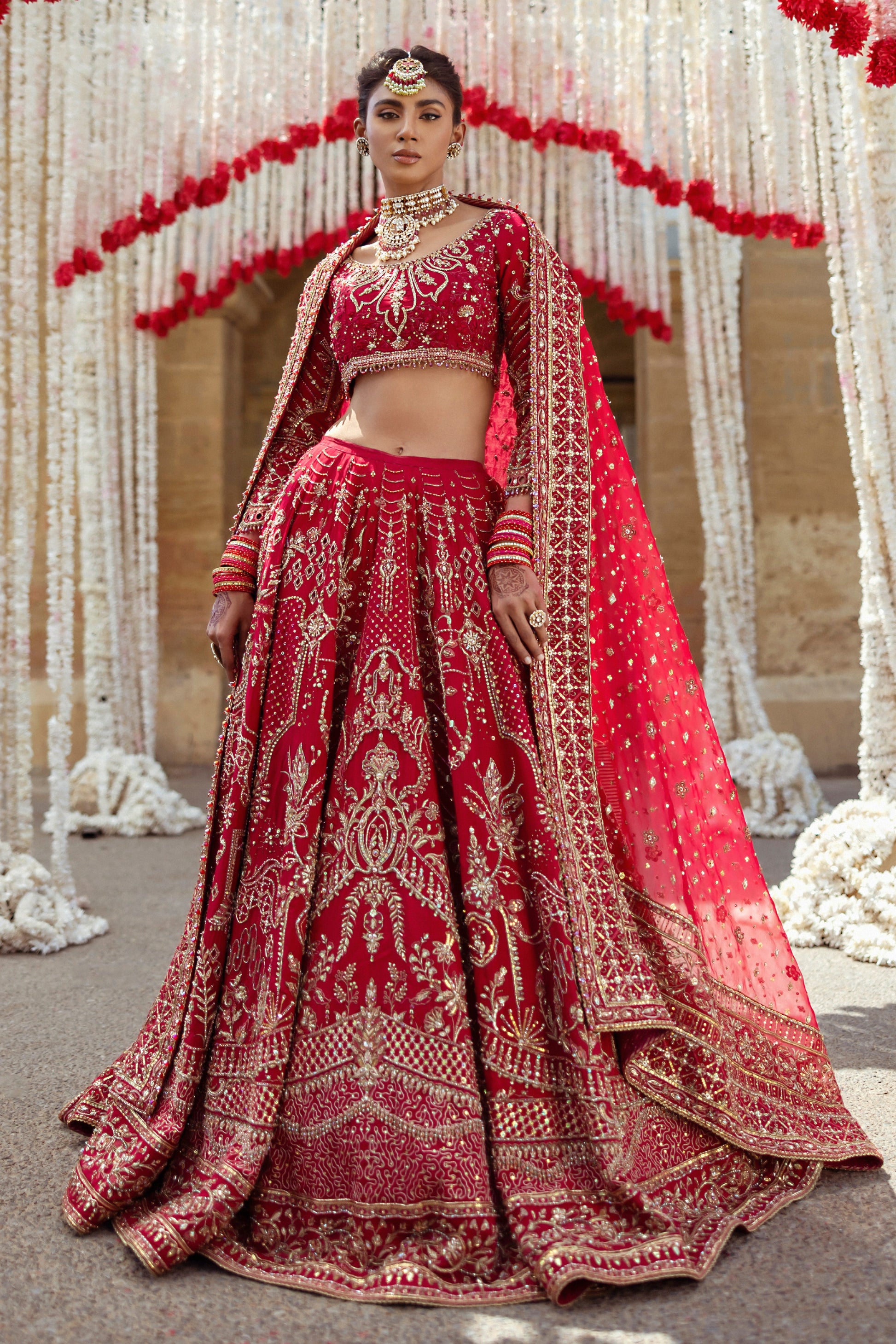 Full standing pose of Qurbat fuchsia red wedding dress showing wide lehenga flare and long dupatta fall, traditional ready made bridal attire.