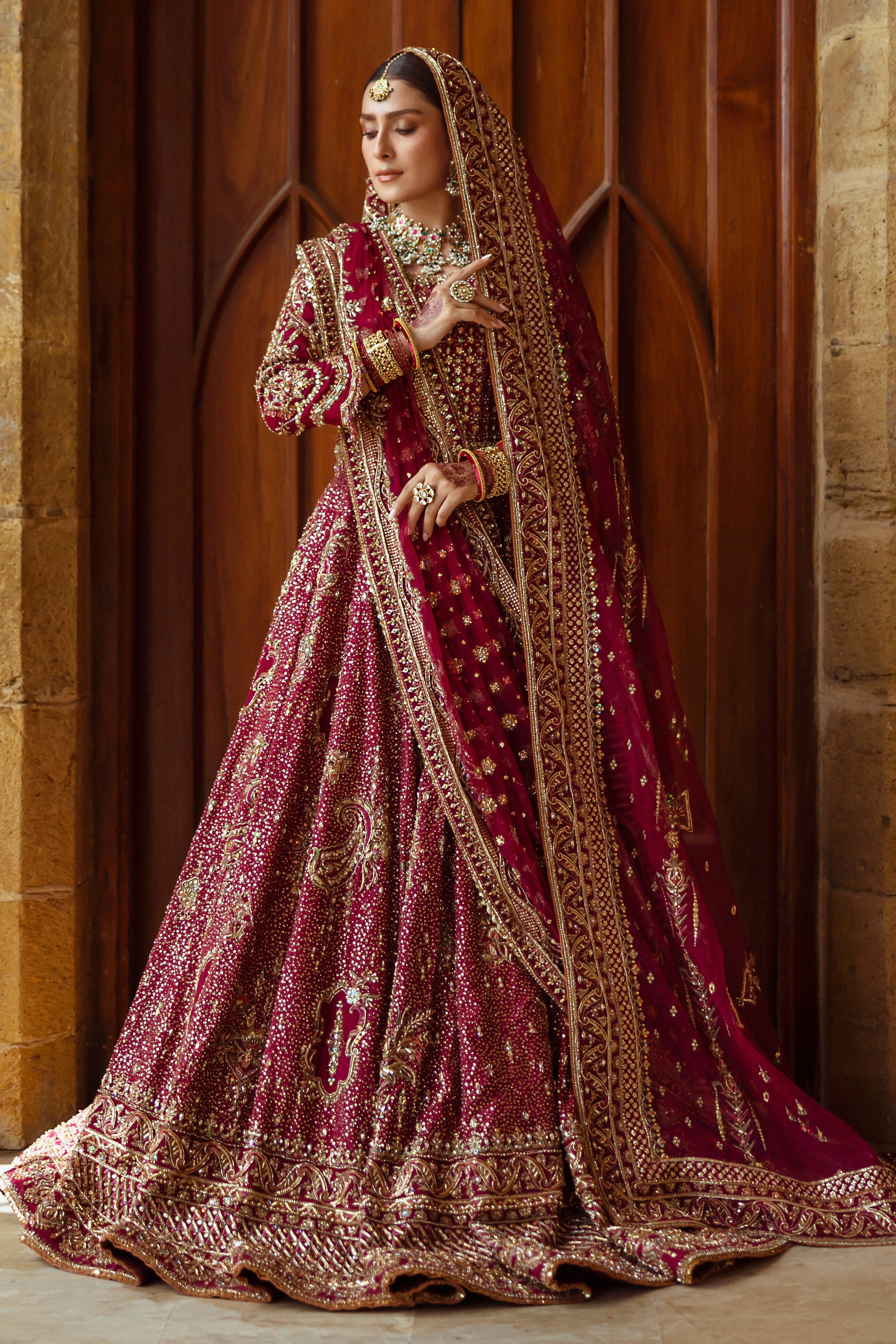 Full standing look of Kandhari plum lehenga choli featuring layered borders and rich embroidery, complete formal barat wedding outfit.
