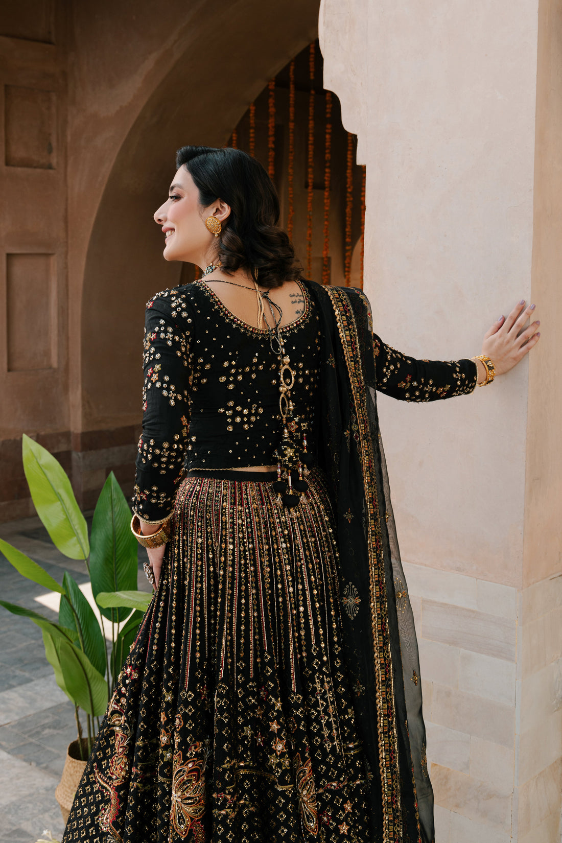 NAQSHI Kaif black Indian raw‑silk lehenga choli with boat neckline, fully hand‑adda embellished choli and heavily jeweled lehenga, styled front on