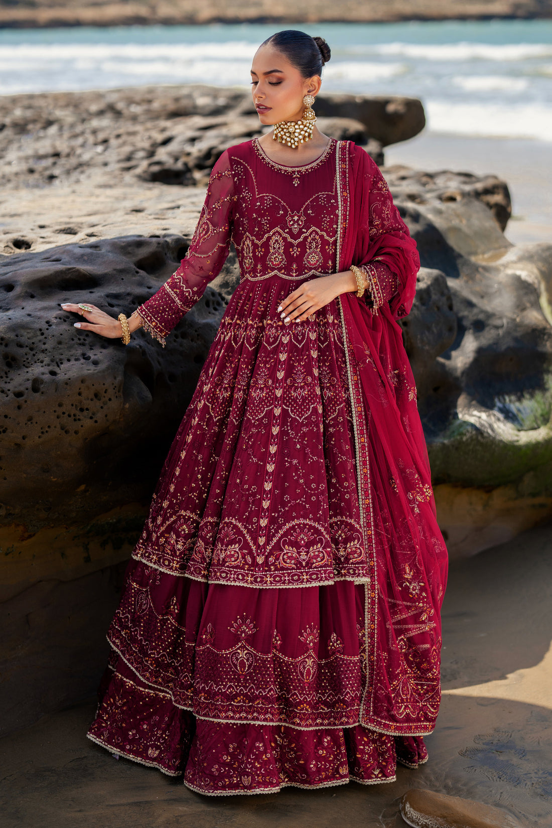 NAQSHI Zureal layered floor-length burgundy crinkle frock with round neckline, composed bodice richly embellished with hand‑adda embroidery, sequins & handmade hangings.