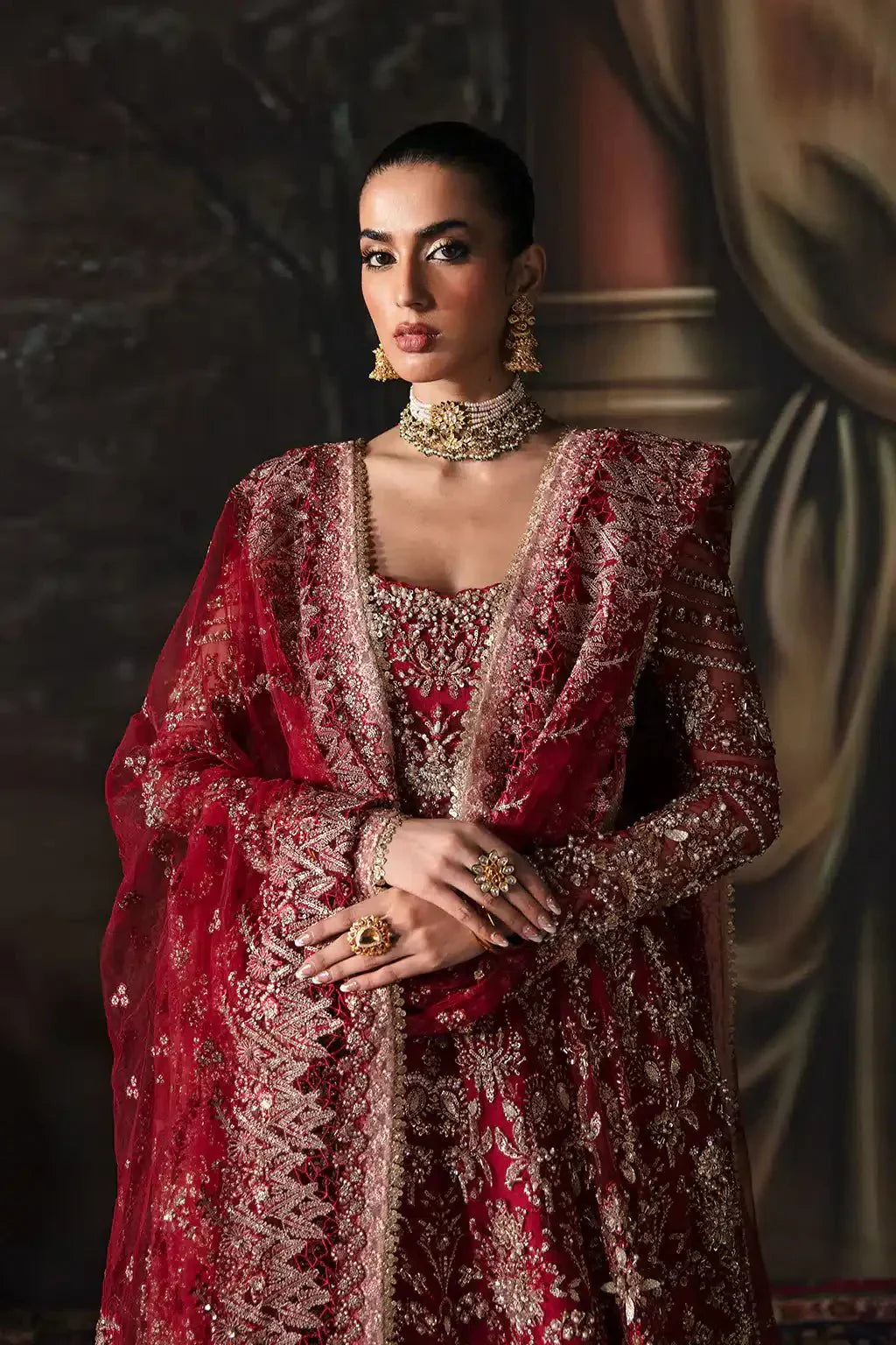 Close-up of Afrozeh The Brides Edit 23 Adelaide bridal dress showcasing detailed neckline embroidery and jewelry styling in rich brick red net fabric.