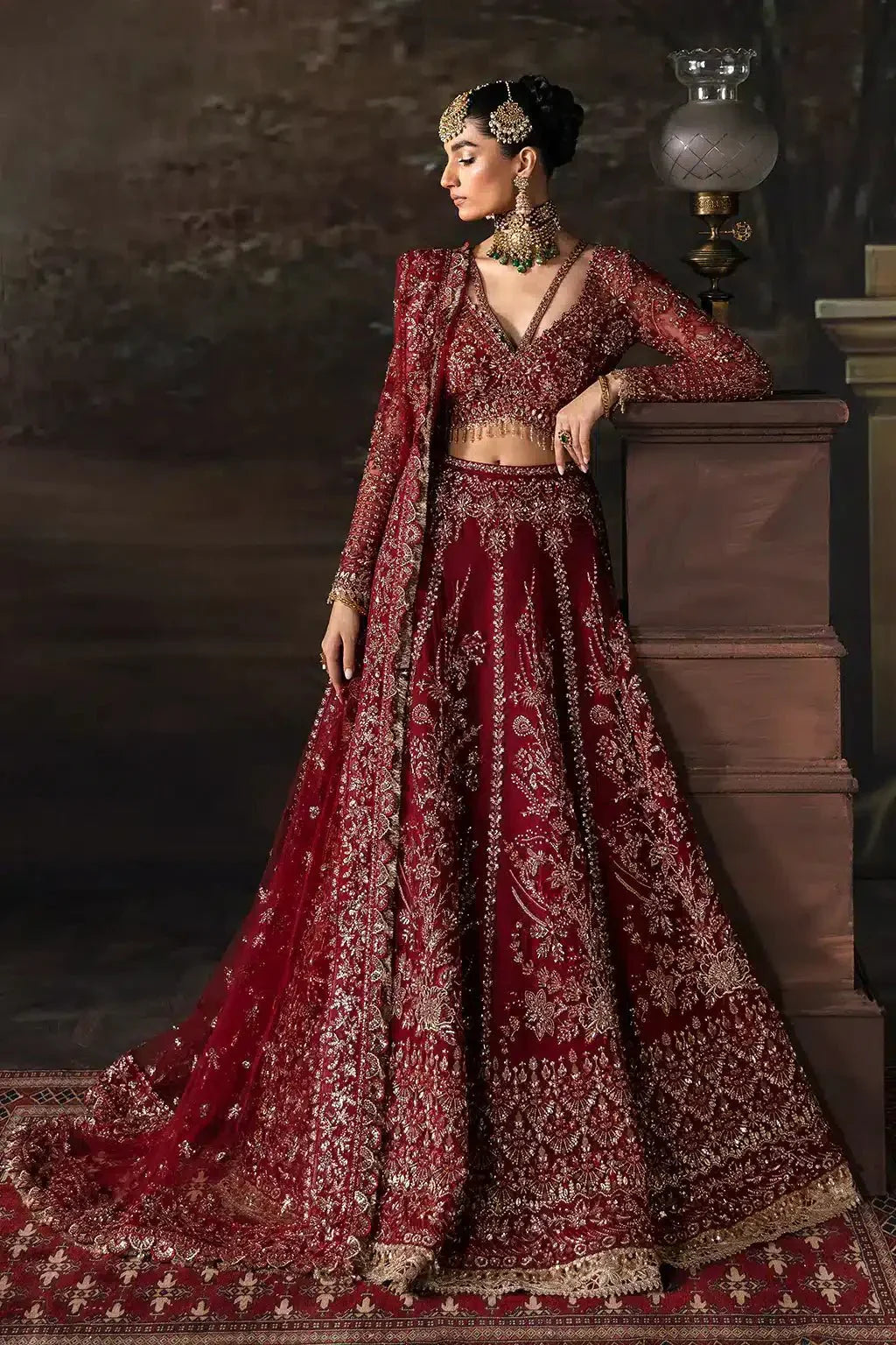 Afrozeh The Brides Edit 23 Emmaine bridal lehnga choli in maroon net with intricate gold embroidery, styled with traditional jewelry.