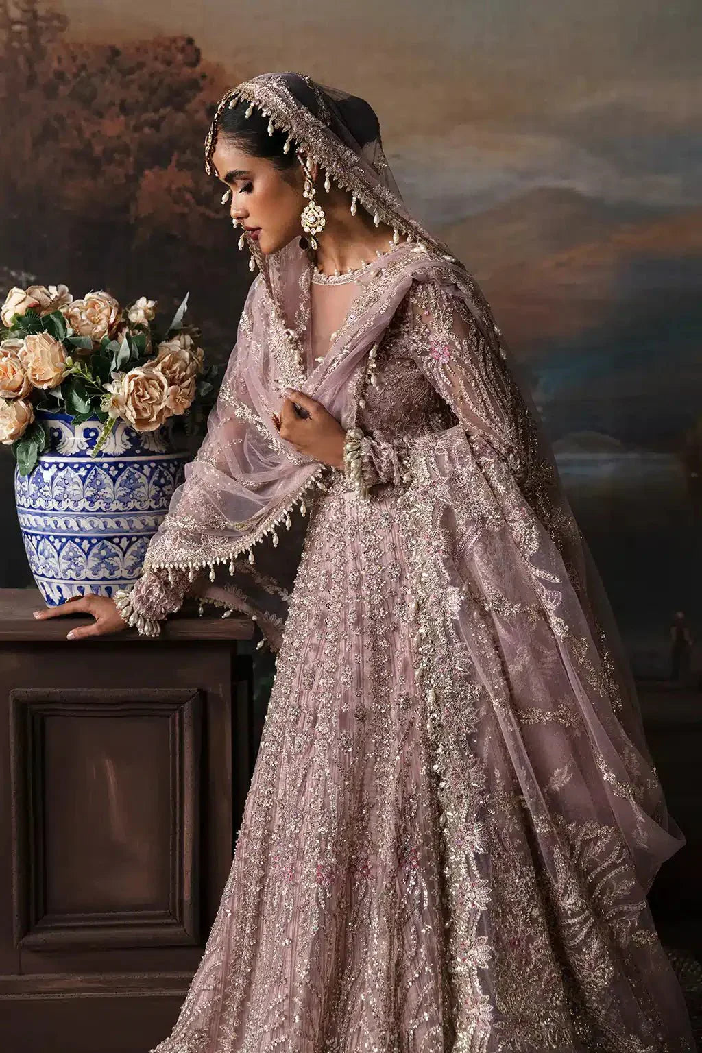 Side pose of model in Afrozeh The Brides Edit 23 Isabella bridal dress, showcasing detailed embroidery and matching dupatta with tassels.