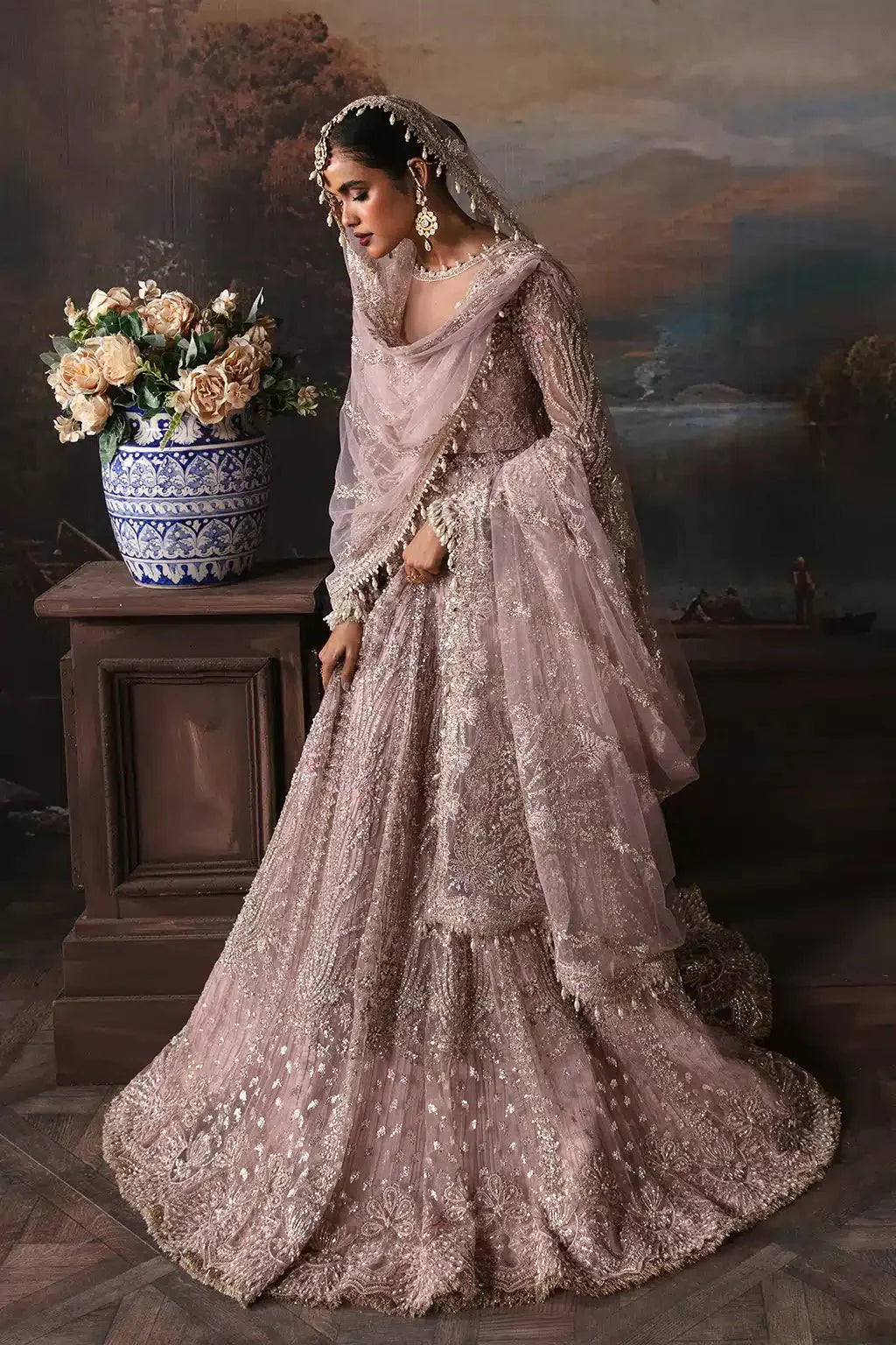 Afrozeh The Brides Edit 23 Isabella bridal outfit styled with veil and floral backdrop, highlighting luxurious net fabric and embroidery.