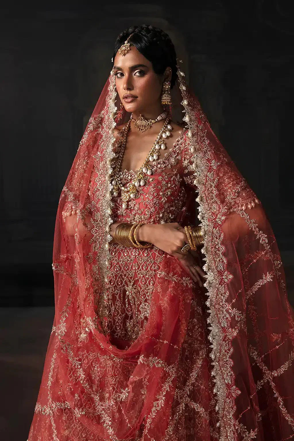 Afrozeh The Brides Edit 23 Lavinia bridal outfit in rust with net dupatta and gold embroidery, styled with bridal jewelry.