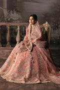Seated model in Afrozeh The Brides Edit 23 Victoria bridal dress, highlighting the luxurious embroidery and regal tea pink organza fabric.