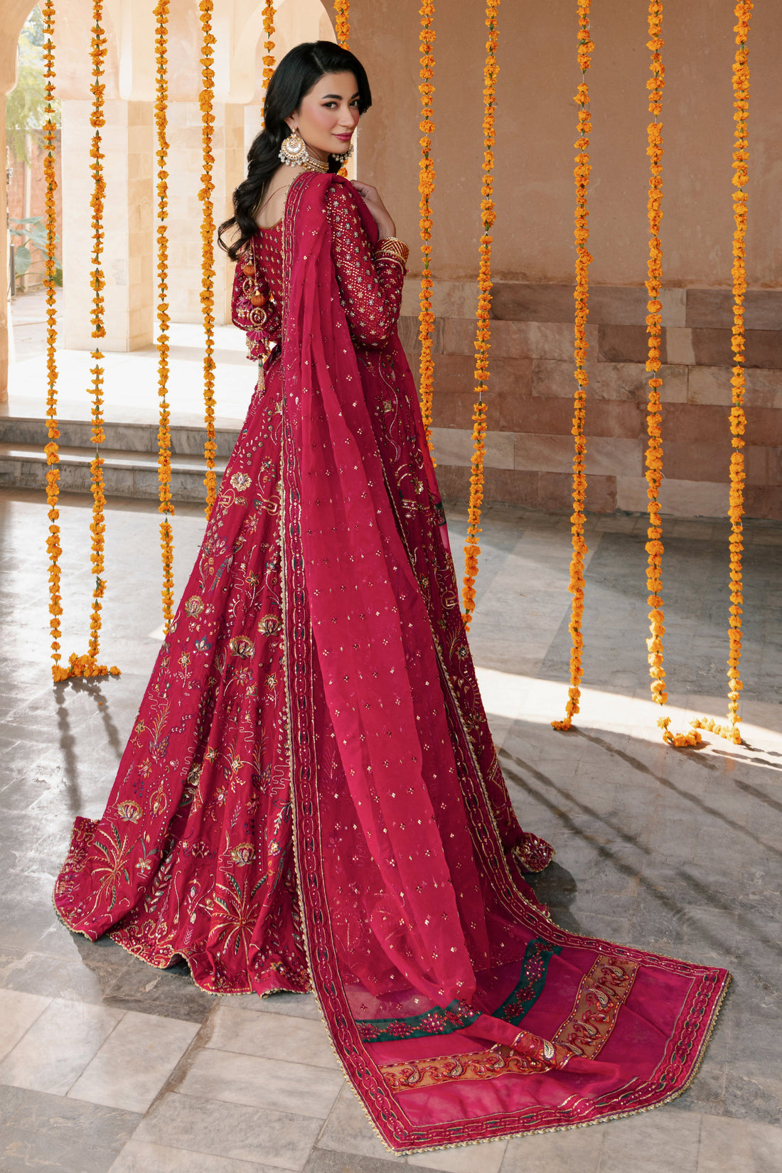 NAQSHI Nageen hot‑pink raw‑silk lehenga choli with boat neckline, heavy sequin embroidery on front bodice, lush floral motifs on lehenga and matching embellished organza dupatta