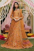 Model styled in full NAQSHI Romanvi 3PC set: tangerine raw‑silk lehenga choli, boat-neck choli, handmade tassels and embroidered organza dupatta